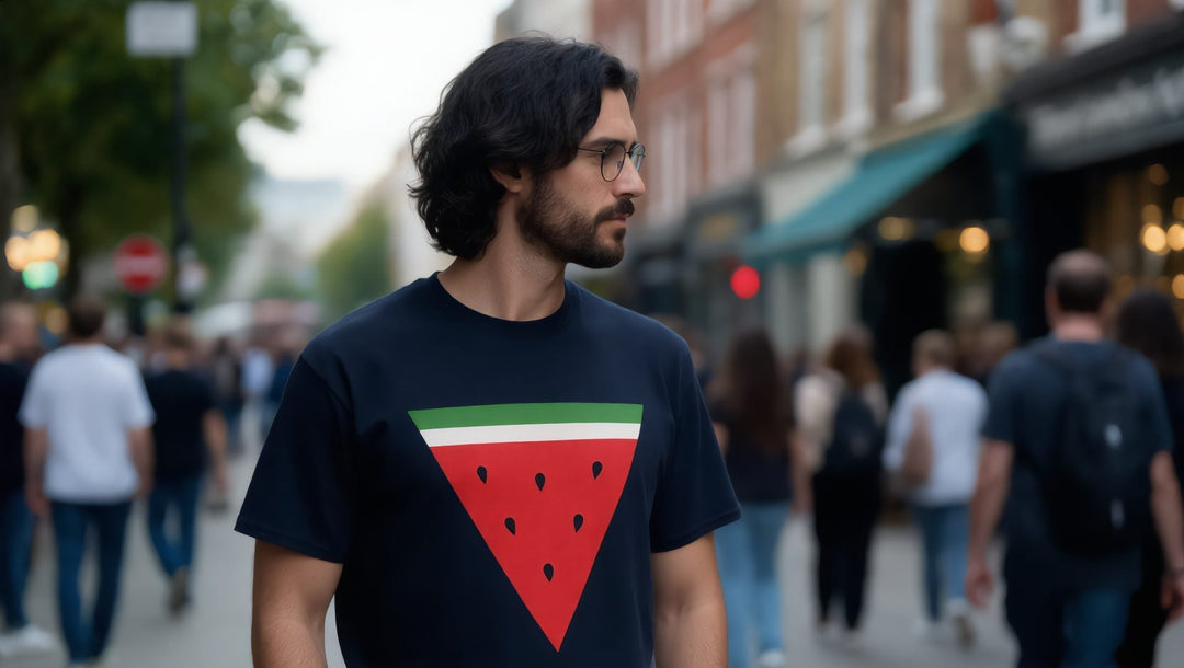 Man in a navy watermelon triangle T-shirt on a busy street in Brixton, London