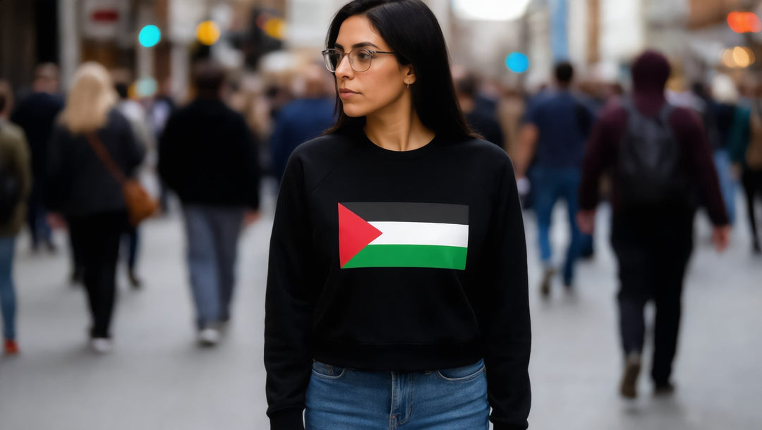 Woman in a black Palestine flag raglan sweatshirt on a busy street in Marylebone, London