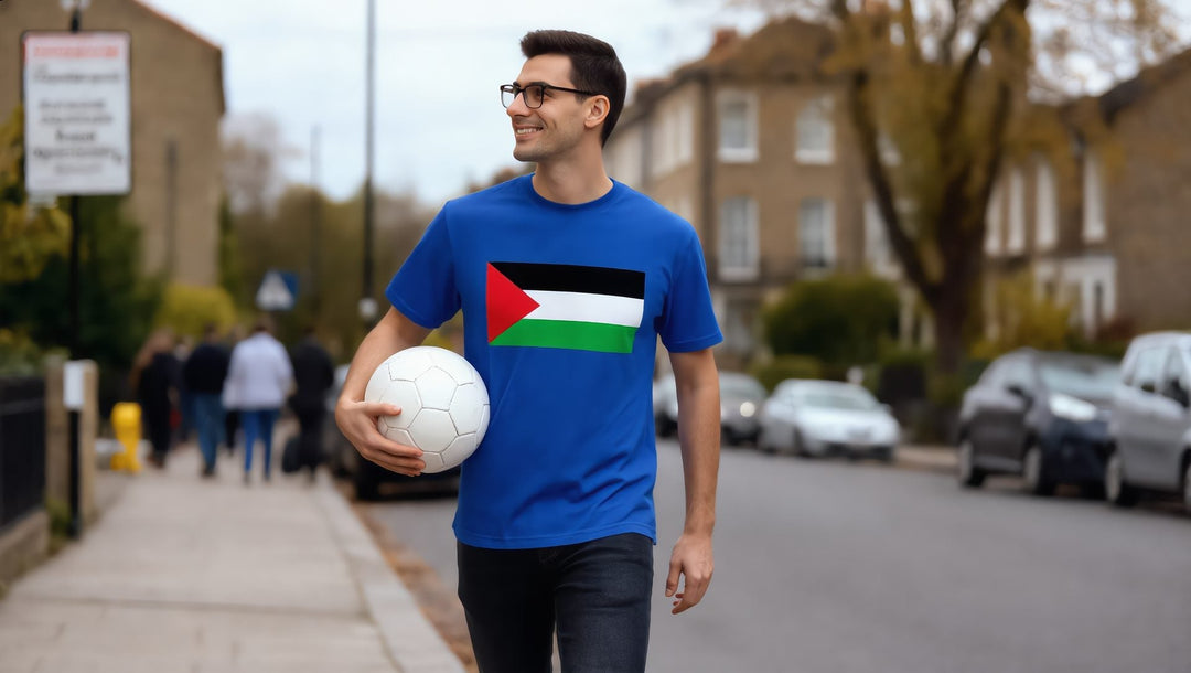 Man in a blue Palestine flag t-shirt holding a football on a street in Islington, London